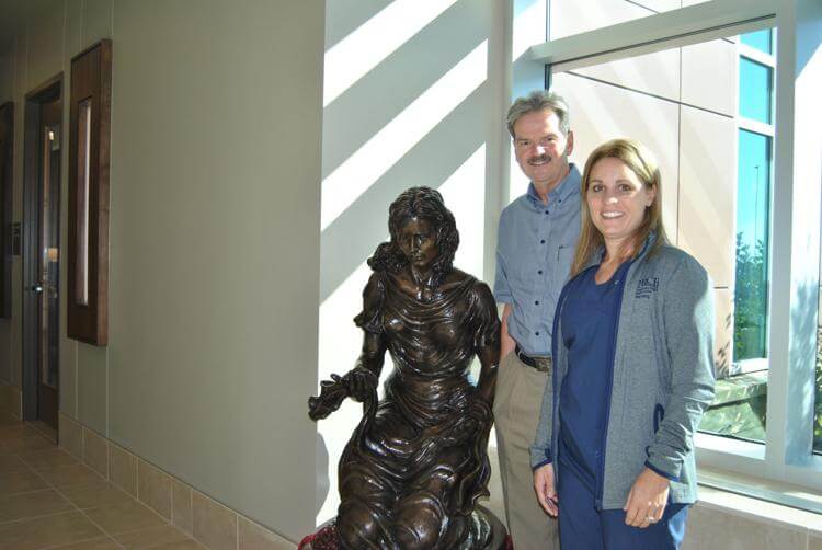 Sam Rennick, executive director of the Beatrice Community Hospital Foundation, and labor-and-delivery nurse Jill Allen stand with the bronze sculpture 