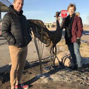 Joe McHale and Sondra Jonson, with Jonson’s sandhill crane bronze at the south entrance to Kearney. 